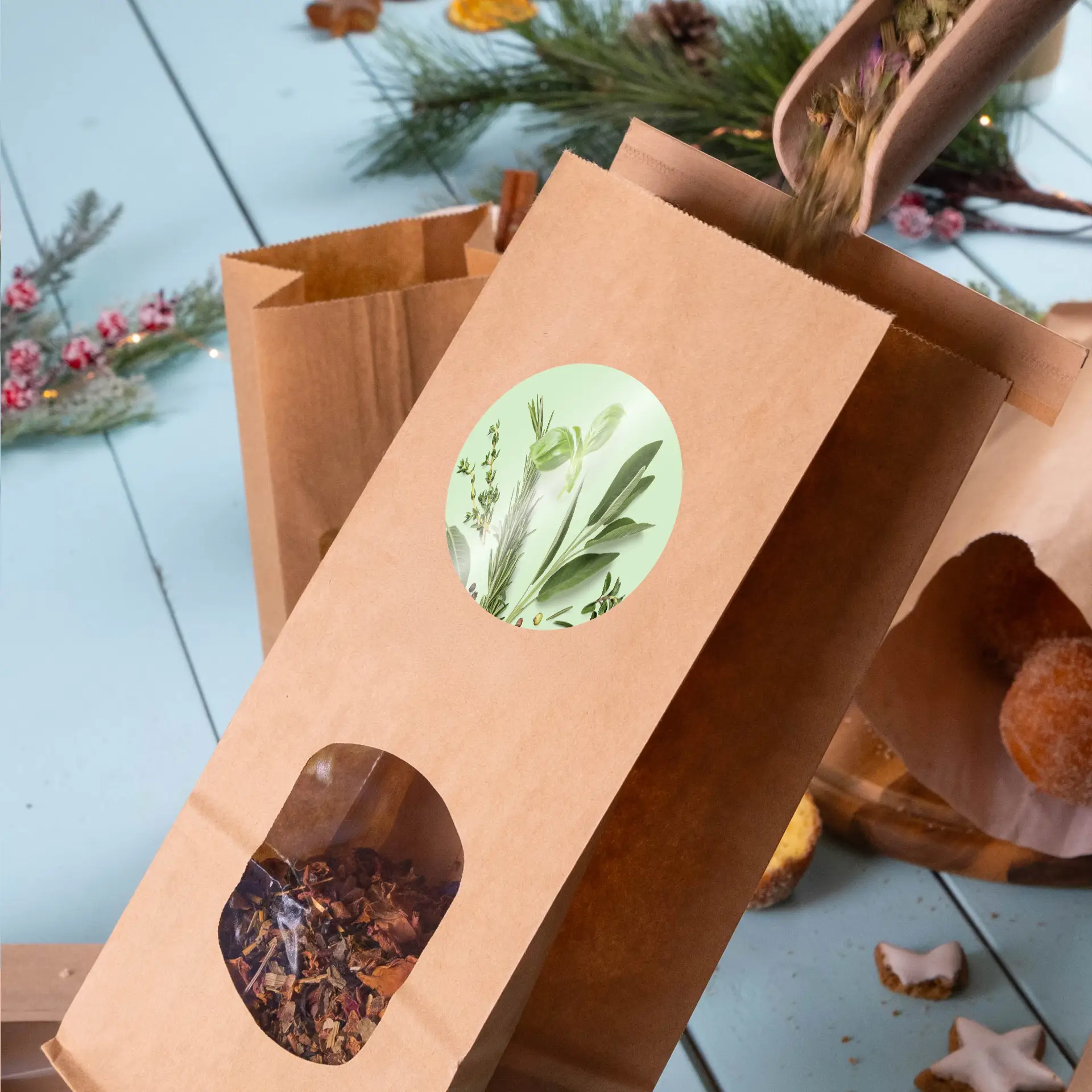 Busta in carta kraft marrone con una finestra che mostra erbe secche, con un'etichetta rotonda dal design botanico.