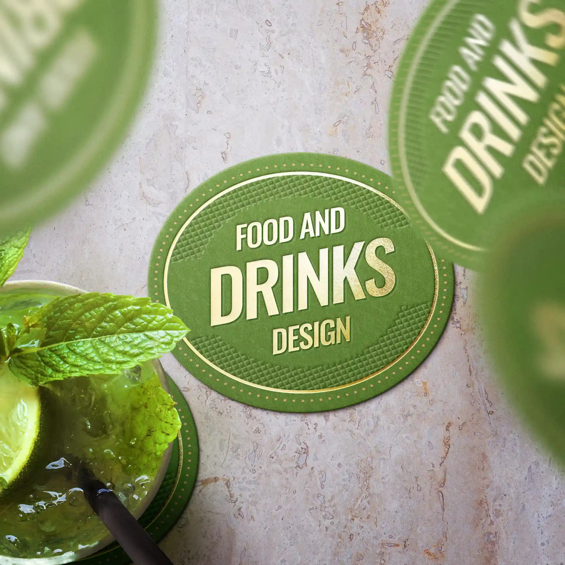 Sous-verre ovale vert avec design textuel, présentant une feuille de menthe et une tranche de citron vert à côté d'une boisson.