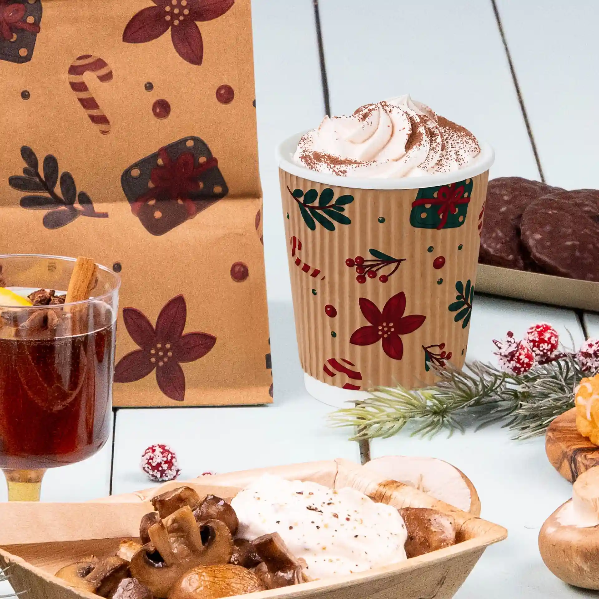 Image d'un gobelet marron de 200 ml avec un design hivernal, rempli de crème fouettée, accompagné de divers en-cas festifs.