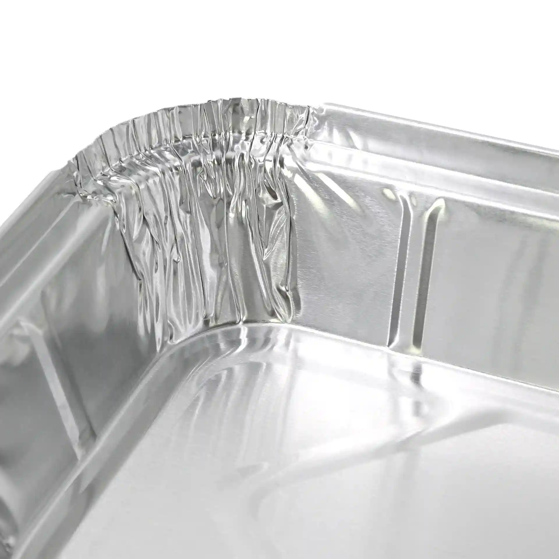 Nahaufnahme der Ecke eines rechteckigen Aluminiumbehälters mit gekrümmten Kanten und glänzender Oberfläche.