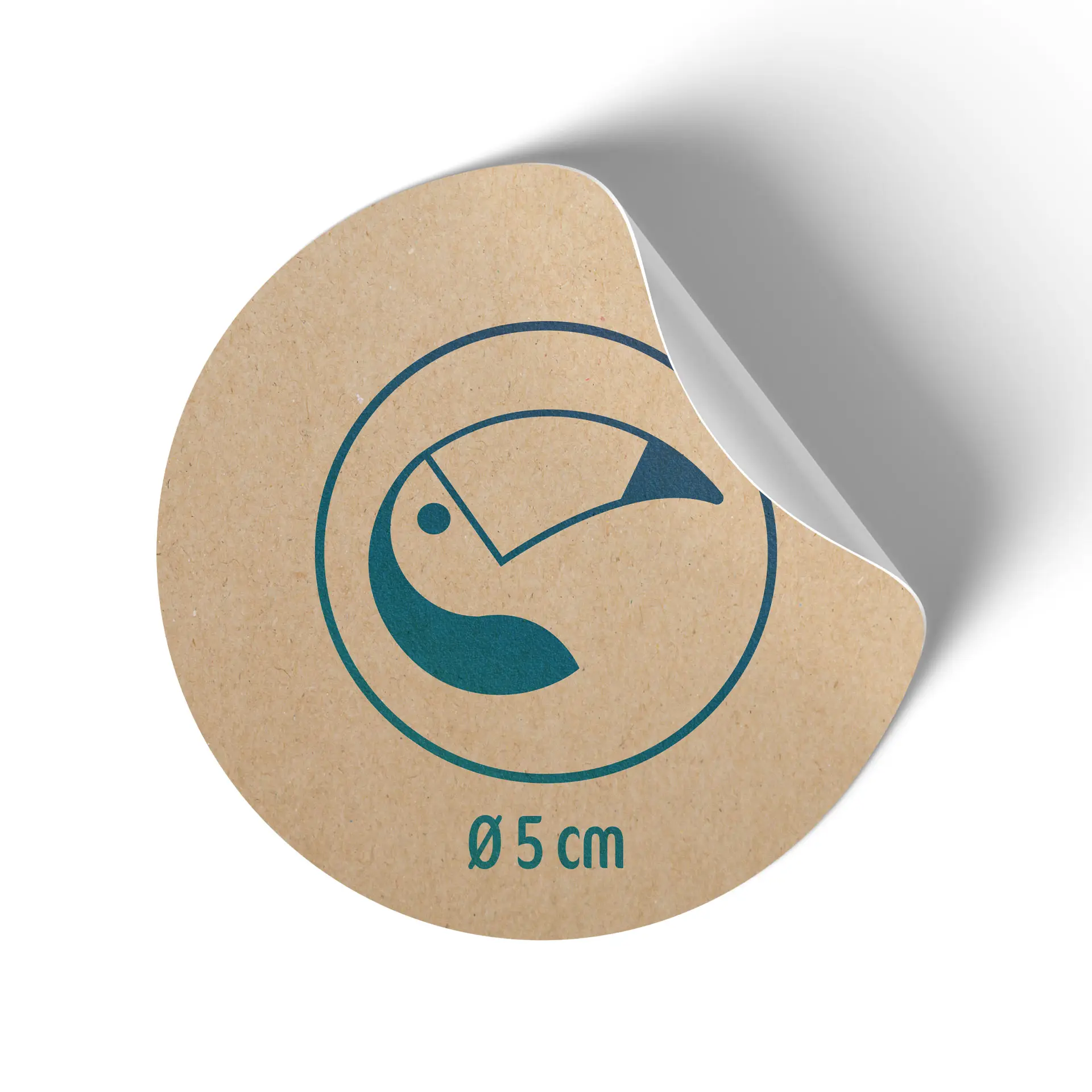 Etichetta rotonda in carta kraft, 5 cm di diametro, con design di tucano blu e retro leggermente staccato.