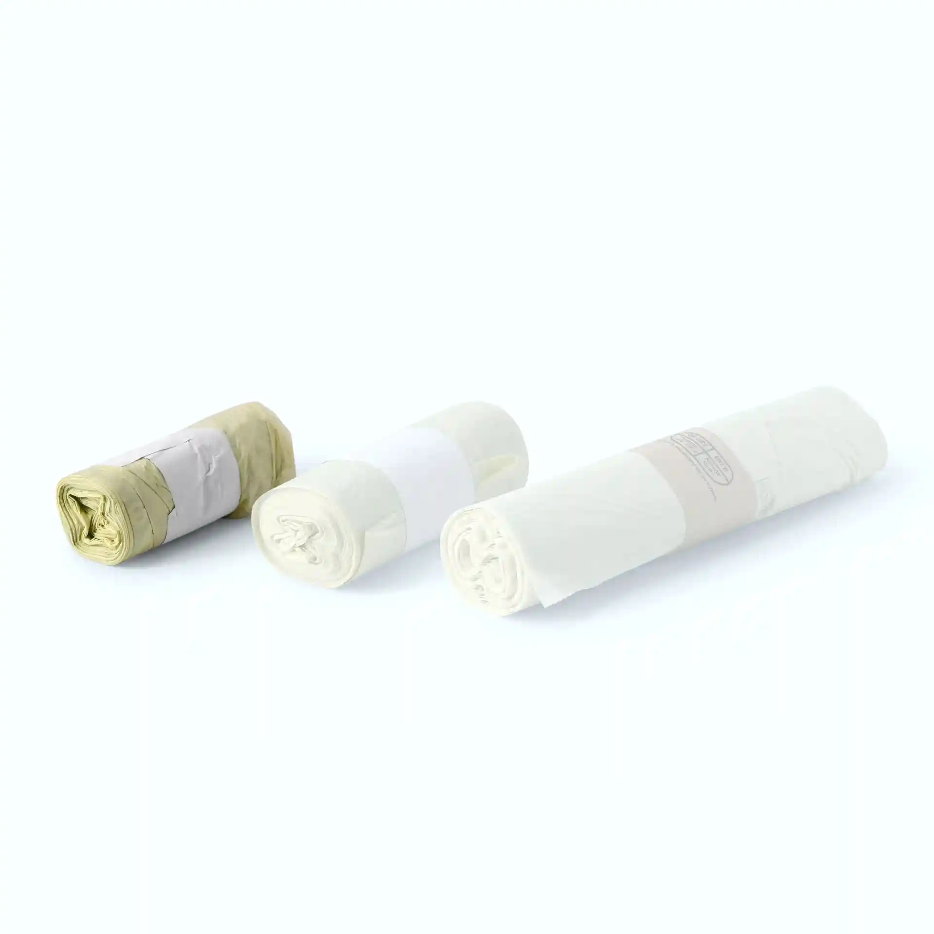 Tre rotoli di sacchetti per rifiuti bio trasparenti in PLA, ciascuno con etichette di colore diverso.