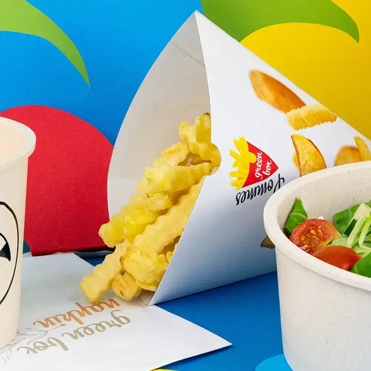 Contenant rempli de frites dorées, avec une étiquette "Pomme de terre Bio" et plusieurs frites à côté.