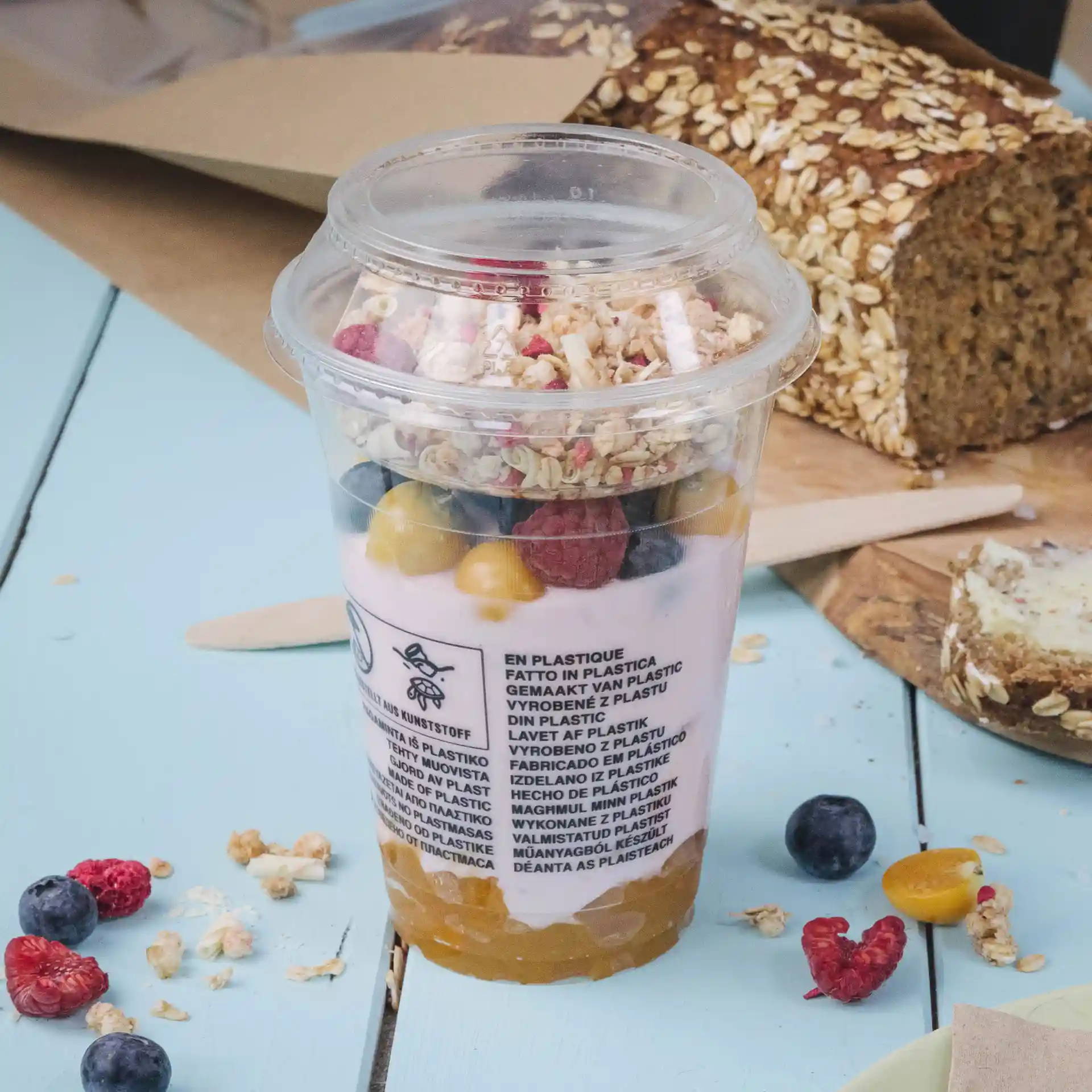 Klarer Kunststoffbecher gefüllt mit Joghurt, Granola und gemischtem Obst, Durchmesser 95 mm.