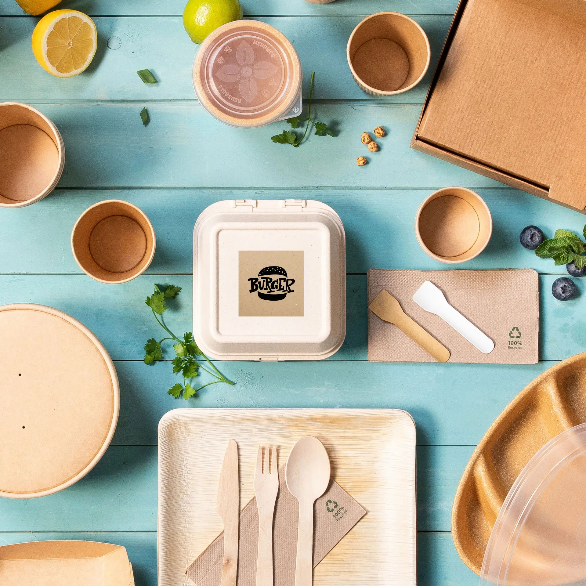 Un contenant carré en papier kraft avec un logo de burger, entouré de divers emballages alimentaires jetables et ustensiles.