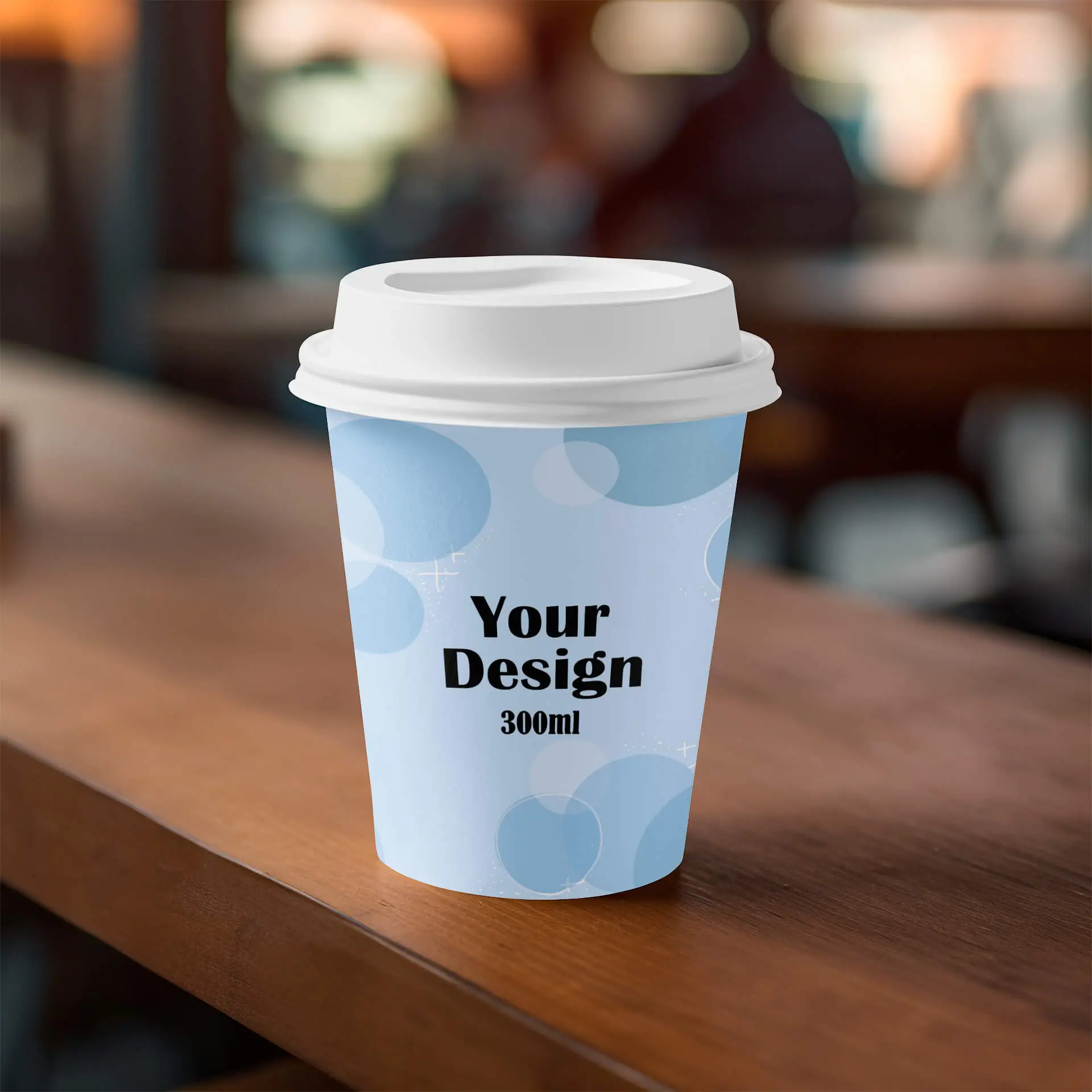 Gobelet en papier à paroi simple avec design personnalisé, capacité de 300 ml, fond bleu avec motif, posé sur une surface en bois.