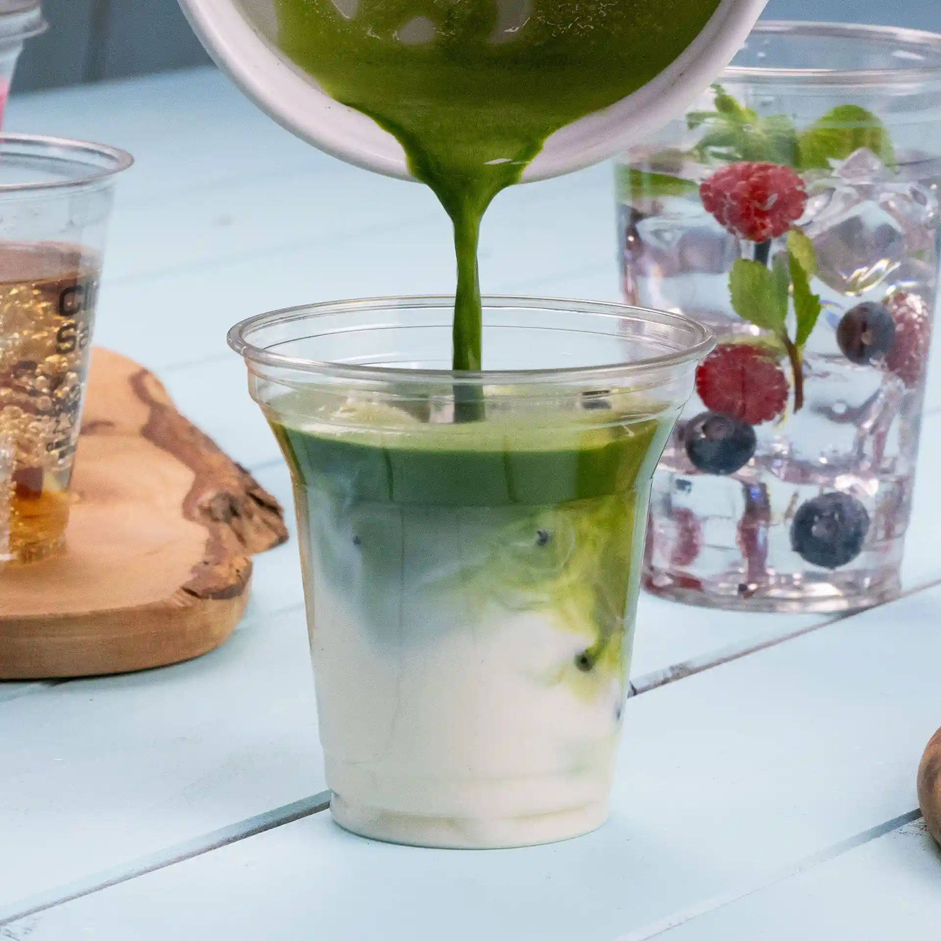 Gobelet rPET transparent de 8 oz rempli d'une boisson verte, montrant des couleurs superposées de vert et de blanc.