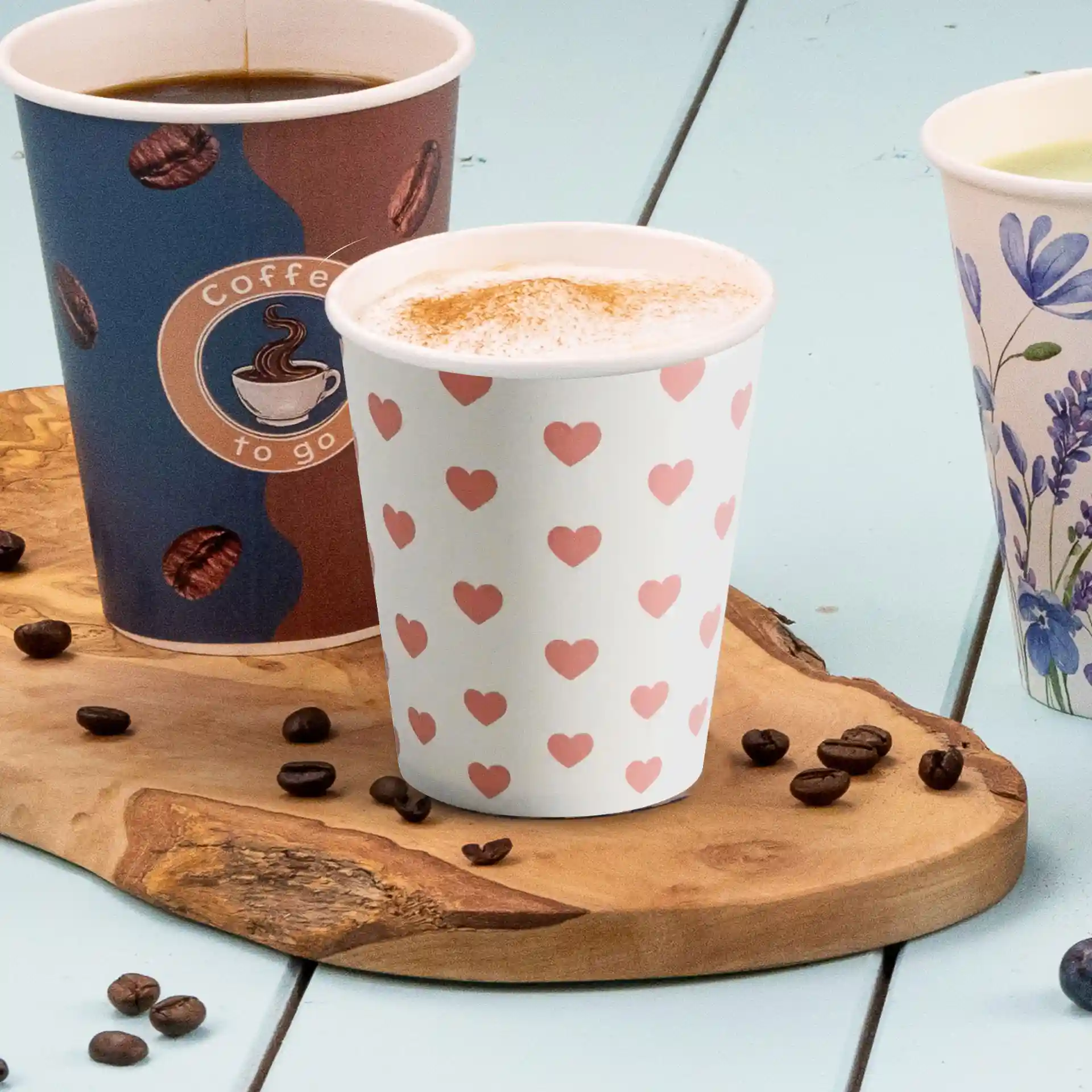 Bicchiere di carta bianco rotondo con motivo a cuori rosa, capacità di 8 oz, posato su una superficie di legno con chicchi di caffè.
