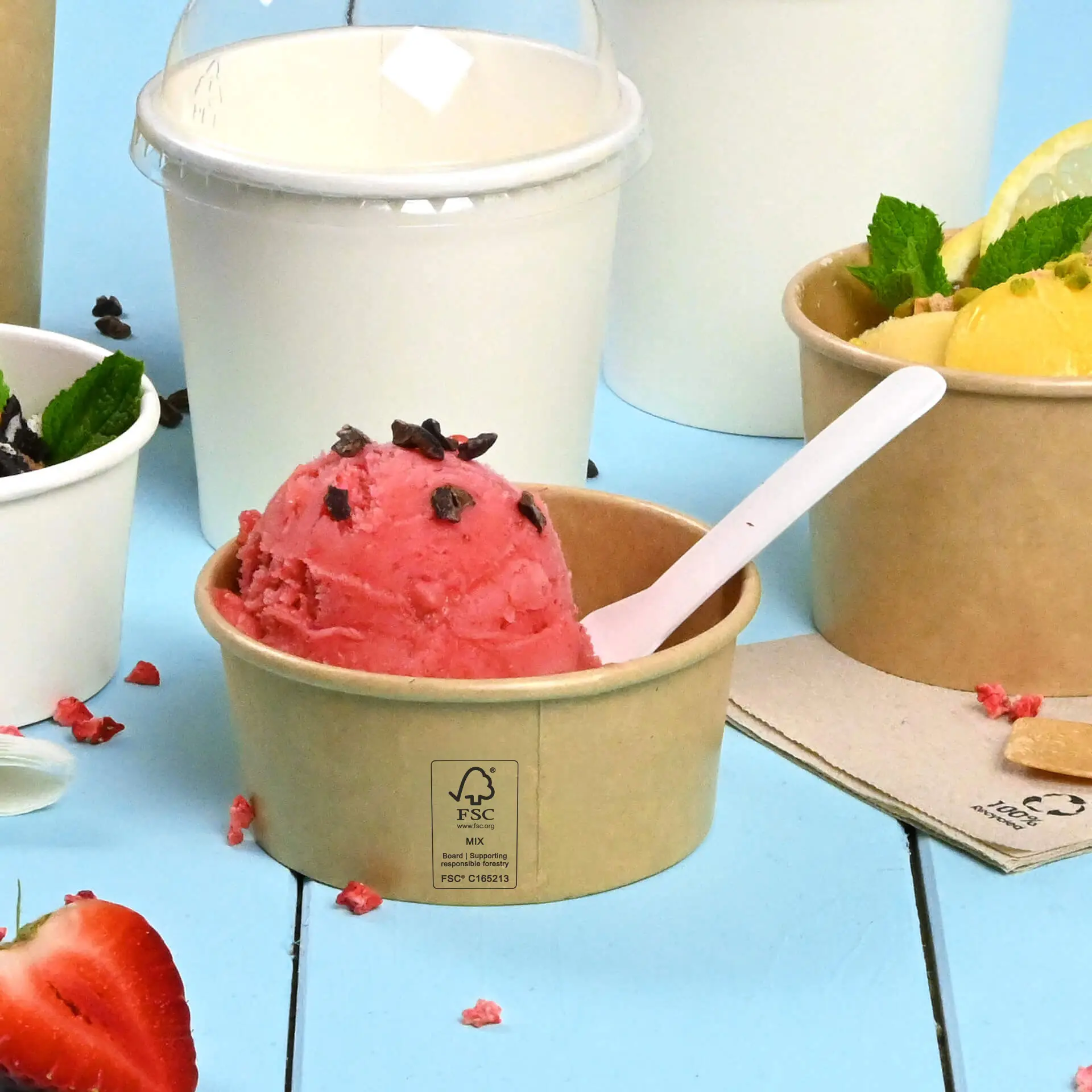 Un cup di gelato marrone, rivestito in PE, con gelato rosa e granelli di cioccolato; altri contenitori per gelato sono parzialmente visibili.