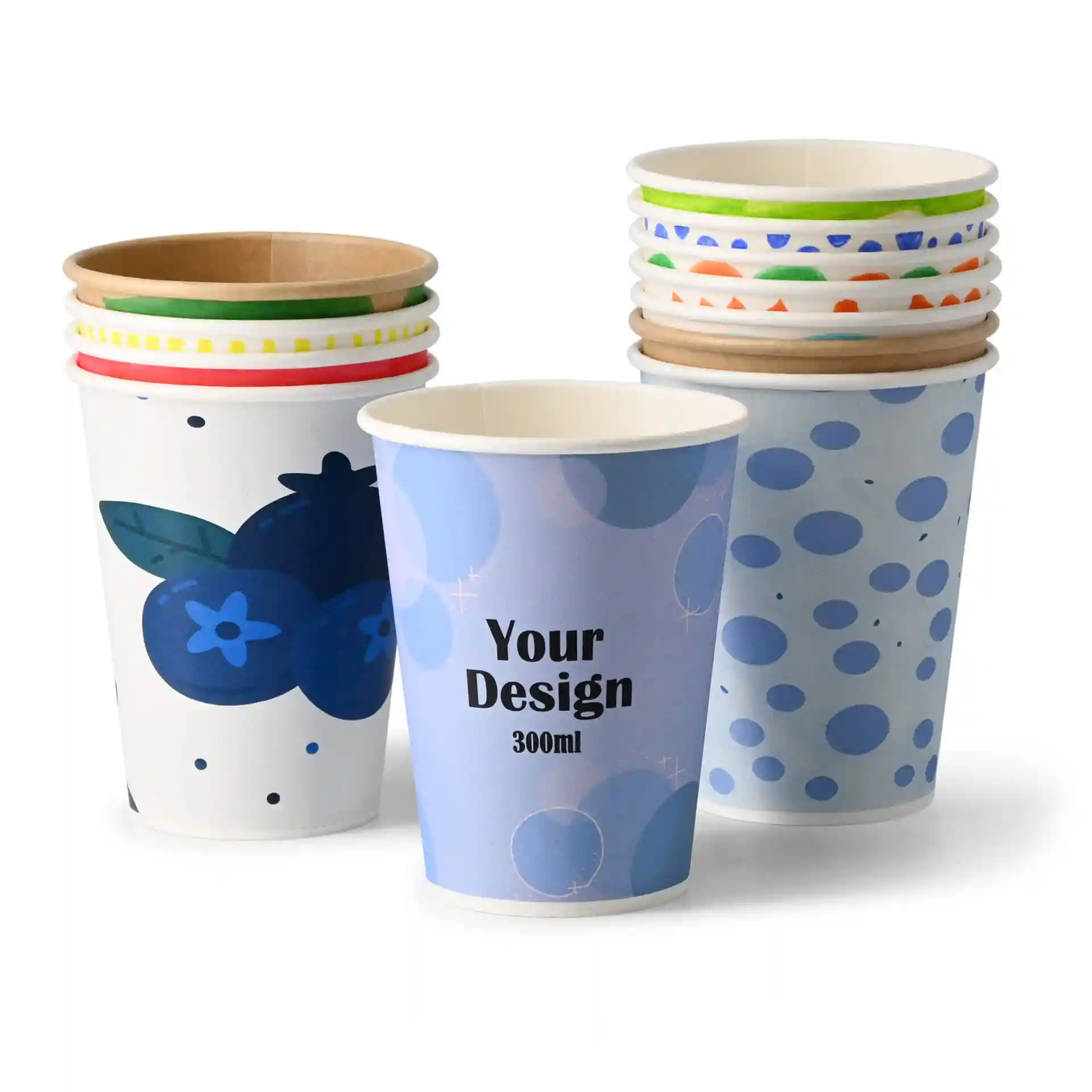 Bicchieri di carta con vari design, tra cui un motivo di mirtilli e un motivo a pois blu, impilati insieme.